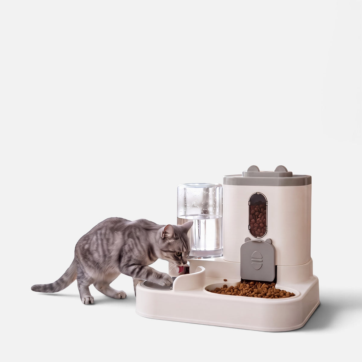 Tailora 2-in-1 automatic pet food and water station with a grey tabby cat drinking from the gravity water bowl