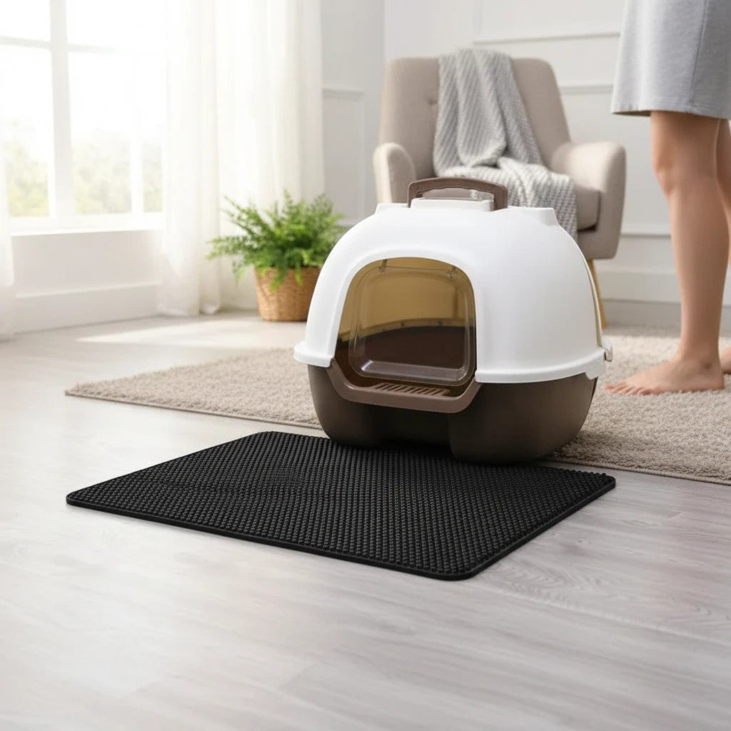 Tailora black honeycomb litter mat placed on a light wood floor in front of a covered cat litter box