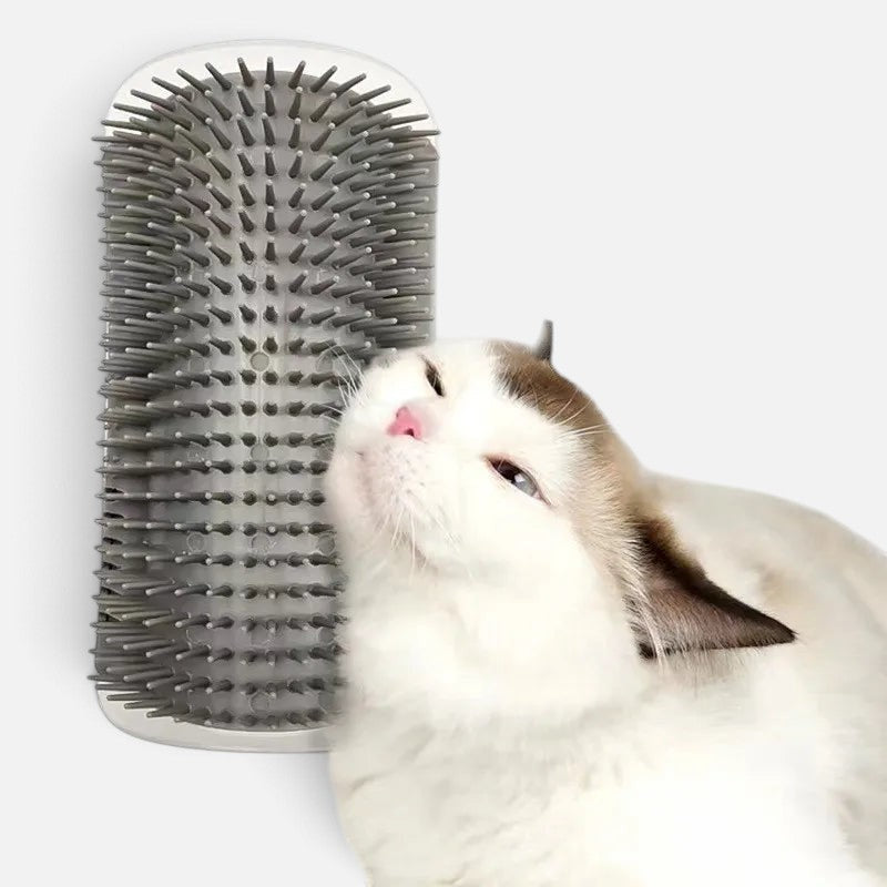 A white cat rubbing against a grey Tailora self-grooming corner wall brush with soft plastic bristles.