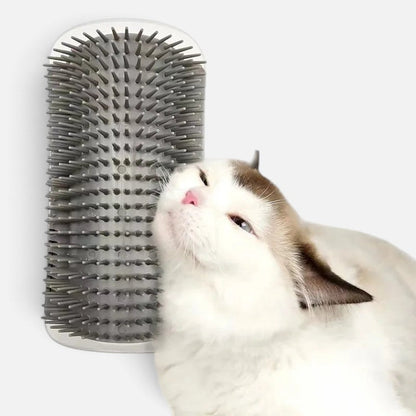 A white cat rubbing against a grey Tailora self-grooming corner wall brush with soft plastic bristles.