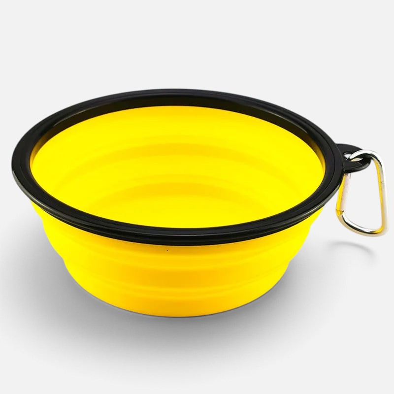 Tailora collapsible yellow silicone pet travel bowl with a black rim and metal carabiner clip for outdoor feeding.