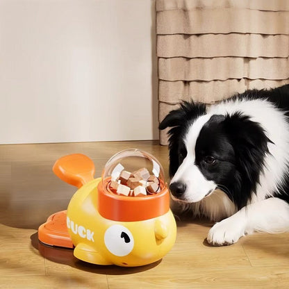Tailora interactive treat dispenser toy shaped like a yellow duck with a clear dome, being used by a border collie.