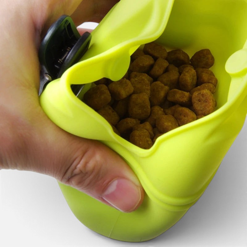 Tailora lime green silicone dog treat pouch being held open to show dry food inside for easy training access.