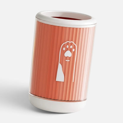 Tailora portable paw washer cup in coral orange with white trim and a cute paw print icon on the side