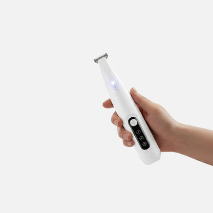 Tailora precision pet trimmer with LED light, held in hand, featuring a narrow stainless steel blade for grooming.